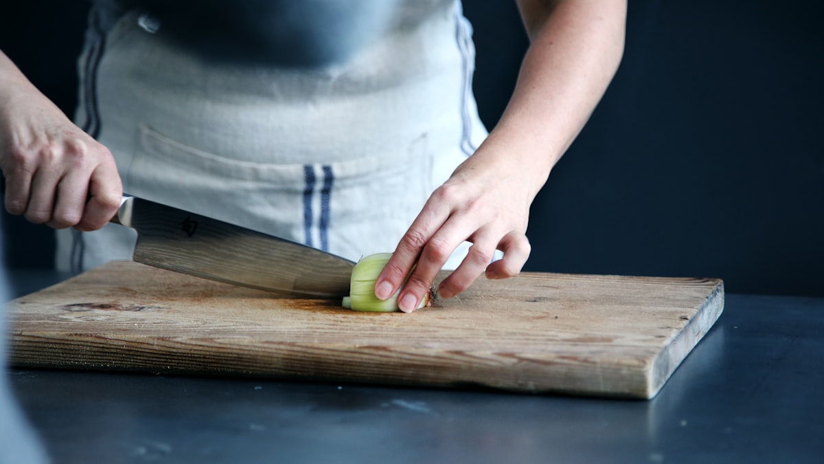 Hands preparing fresh vegetables in a modern kitchen